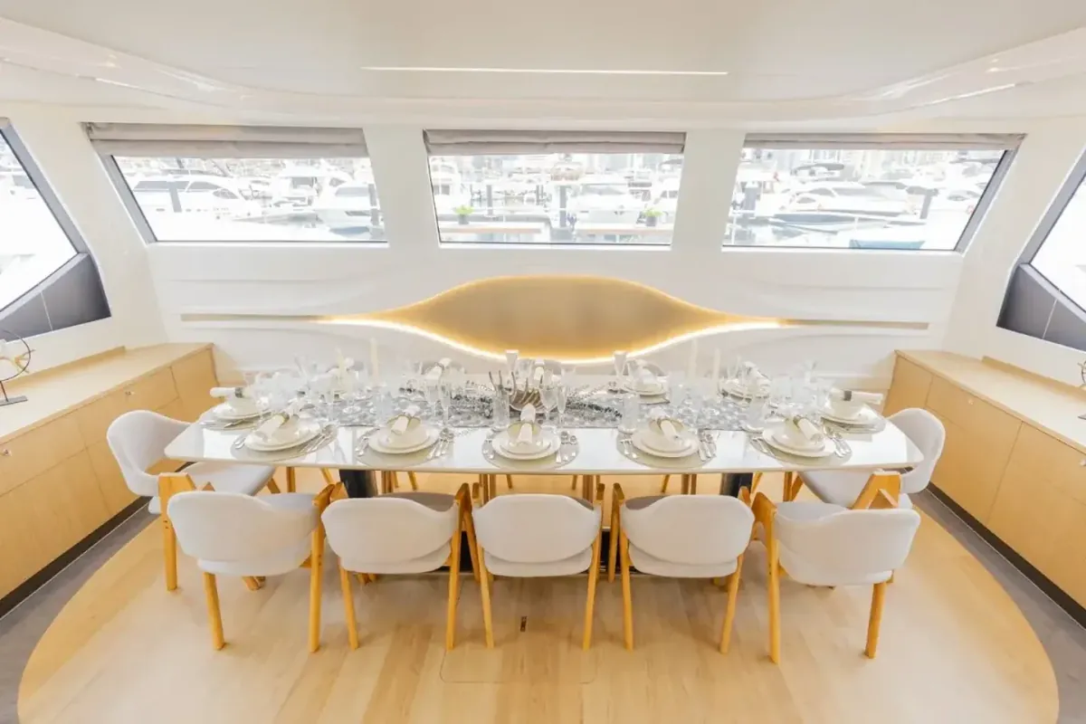Essbereich im Yachtsalon mit einer für zehn Personen gedeckten langen Tafel