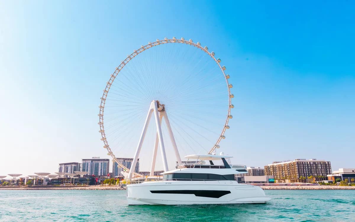 A private yacht on the water in front of the Ain Dubai observation wheel at Bluewaters Island