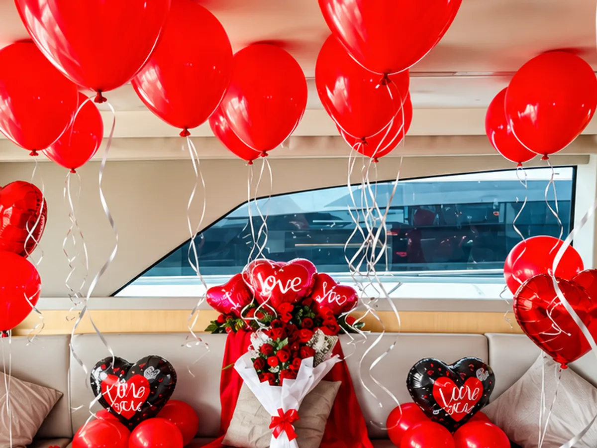 Yacht saloon decorated with red balloons, heart balloons and a bouquet of red roses