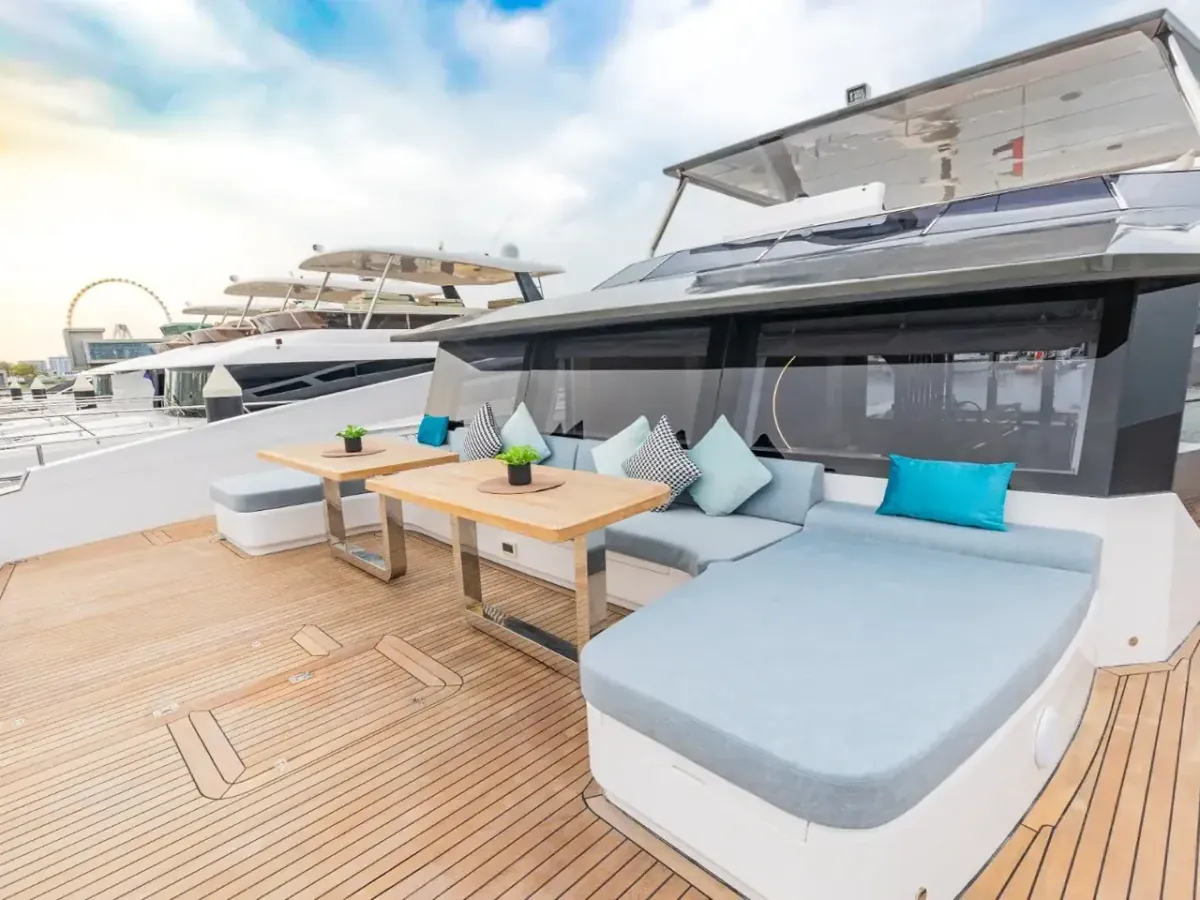 Offenes Loungedeck mit Daybed, gepolsterten Sitzflächen und Beistelltischen, vertäut in einer Marina in Dubai