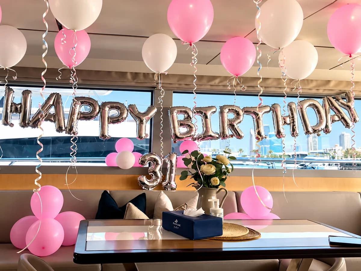 Yachtsalon dekoriert mit rosa und weißen Luftballons und einem Geburtstagsbanner