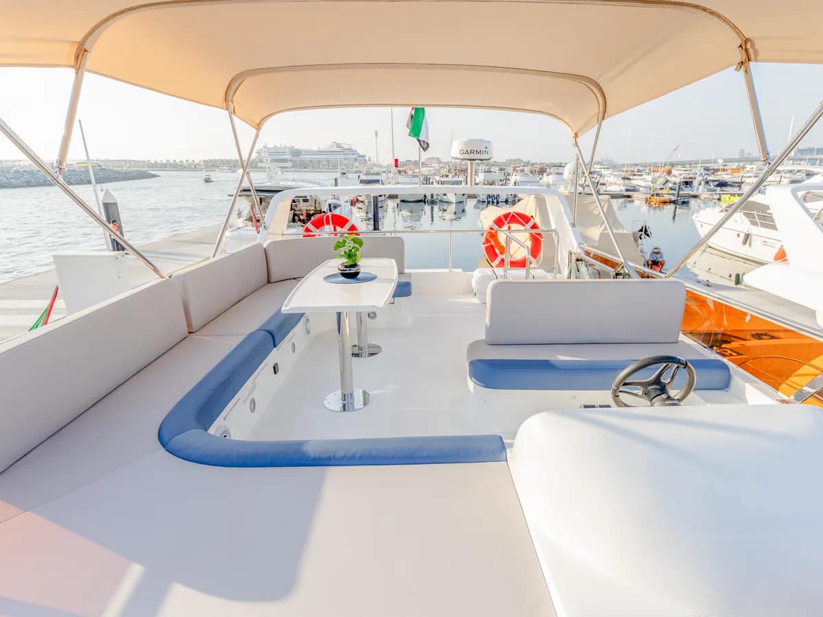 Flybridge seating with a table and sun canopy, moored at a Dubai marina